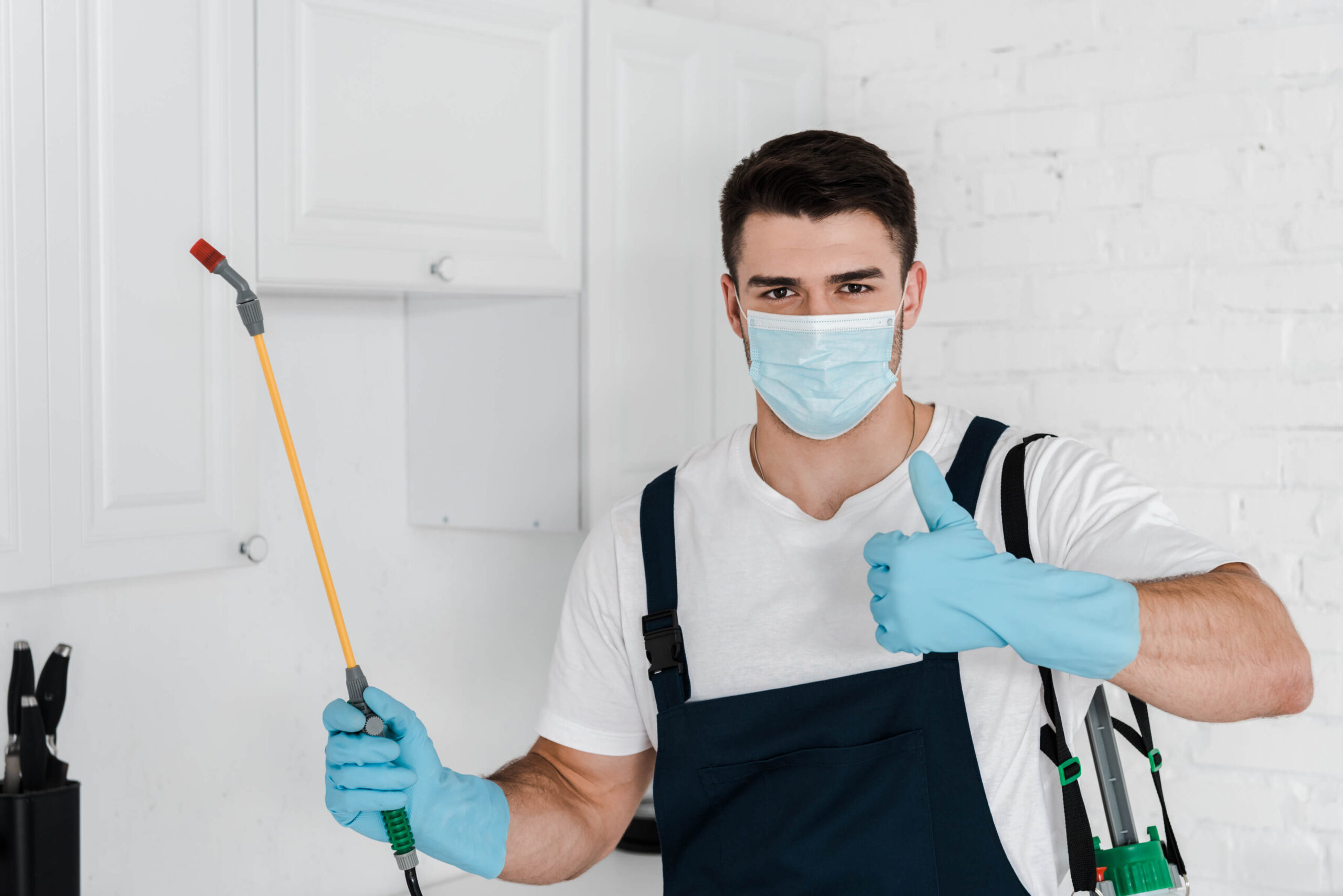 exterminator in uniform holding toxic spray and sh c6c9tcw scaled 1.jpg
